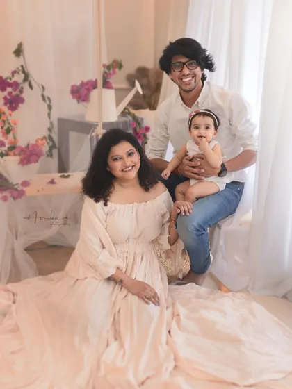 A full family portrait from a bougainvillea-themed sitter session. The coordinated pastel outfits and joyful expressions create a light, happy, and beautiful family memory.