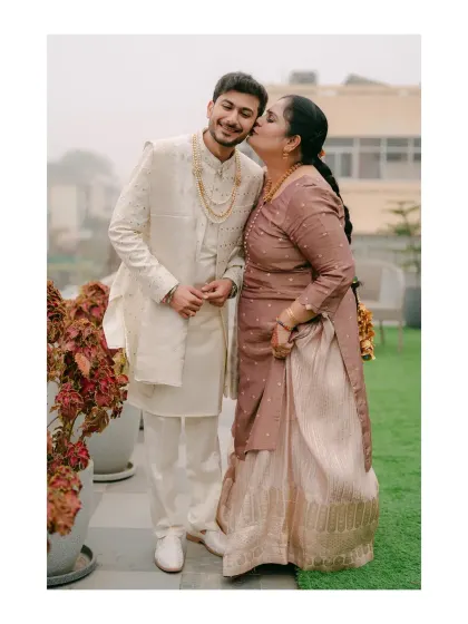A touching moment between the groom and his mother. Her kiss on his cheek is a beautiful expression of a mother's love and pride on her son's wedding day.