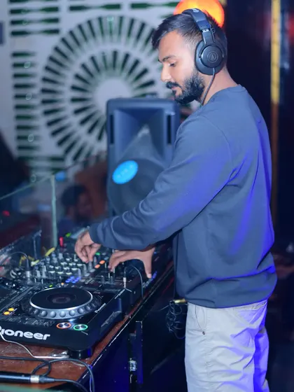 A side profile shot, focused on mixing. This captures the technical side of DJing, where I'm dialing in the EQs and lining up the next beat.