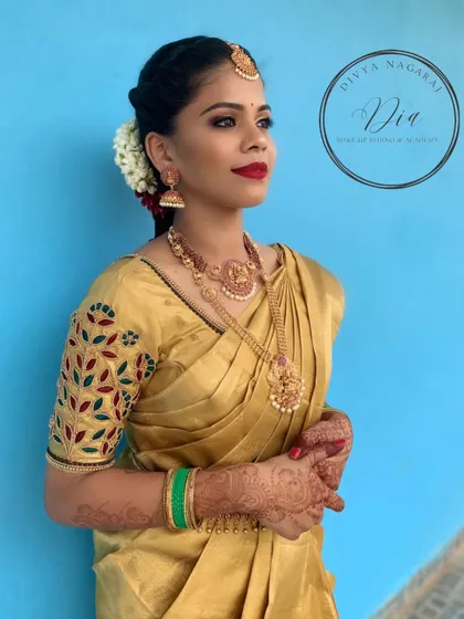 This profile view shows the full bridal attire, including the intricately embroidered blouse and the elegant posture of the bride. The makeup remains flawless, highlighting her features while complementing the richness of her golden saree.