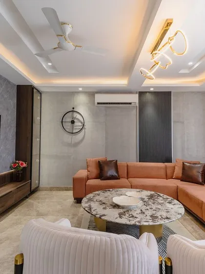 The grey marble-finish wall panels behind the TV create a sleek and modern focal point. The long wooden console provides ample storage and display space.
