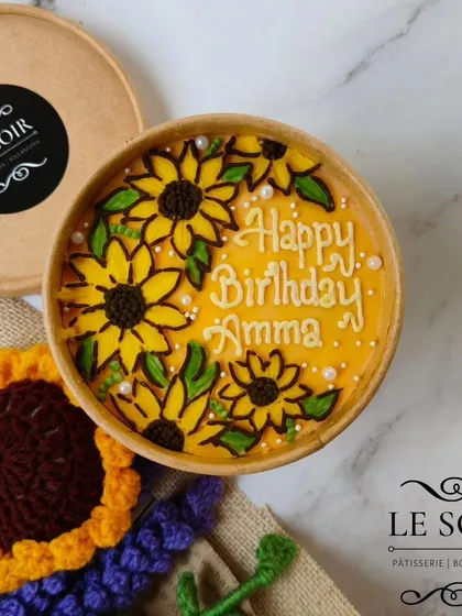 A cheerful sunflower-themed cake tub for a birthday celebration. The bright yellow sunflowers are hand-piped to bring a little bit of sunshine to the special day.