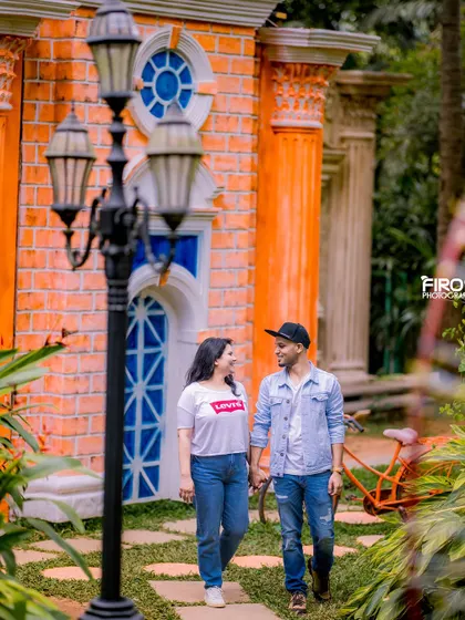 A romantic walk through a garden path. The couple's casual outfits and their hand-in-hand stroll make for a classic and timeless pre-wedding photo.