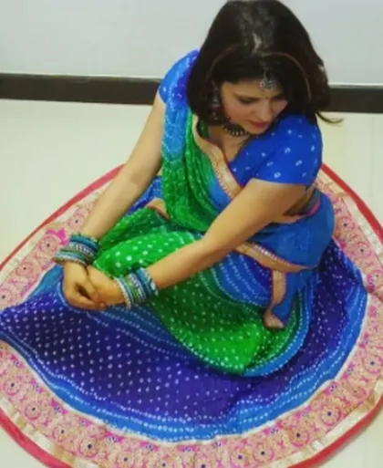 A top-down view of a blue and green Bandhani lehenga, perfect for a Dandiya night. The circular flare is designed for graceful twirls.