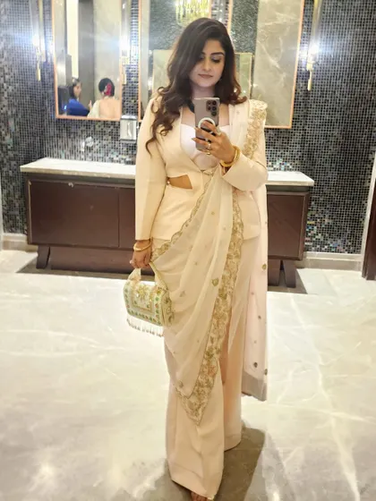 A mirror selfie capturing the side-drape of the zardozi dupatta over the powersuit, highlighting the unique silhouette.