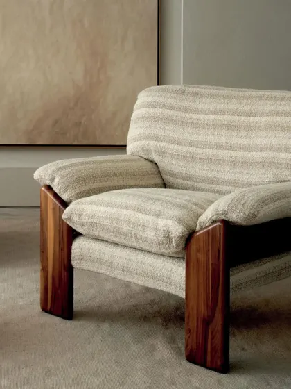 The solid wood frame of this armchair provides a stunning contrast to the soft, woven upholstery. This piece from the Élitis 'Prestige II' collection perfectly balances natural materials with refined textile design.
