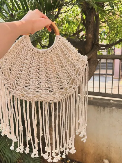 Our macrame half-moon shaped bag with long fringes. This is a true boho statement piece, perfect for festivals or a beach day. It's available in over 12 different colors.
