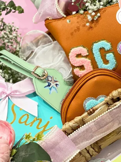 Detail shot of the personalized items in the bachelorette hamper, including a passport holder and pouches with custom initials.
