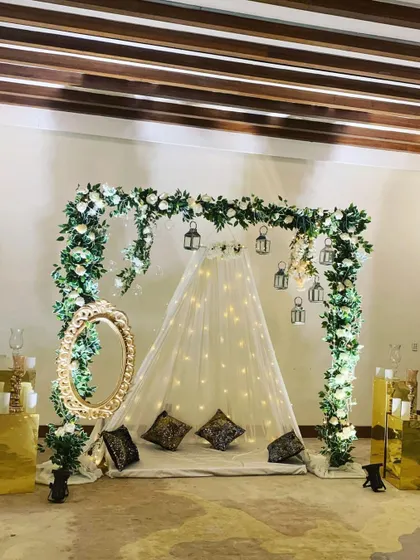 This elegant and romantic setup is perfect for an intimate engagement or bridal shower. It features a canopy of fairy lights under a white floral arch, complete with an ornate mirror and candles for a soft, dreamy look.