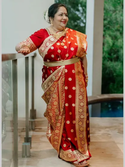 The mother of the bride, looking graceful and elegant. Her hair is styled in a simple bun with fresh flowers, and her makeup is soft and timeless.