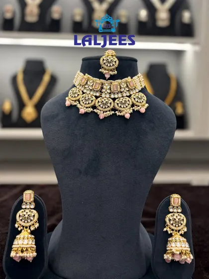 A beautiful pink polki choker set with matching jhumkas and maang tikka. Ideal for sangeet or mehendi functions.