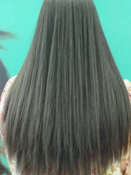 This image shows long, healthy hair after a professional service. The ends are clean and the hair is smooth and straight, ready for any style.