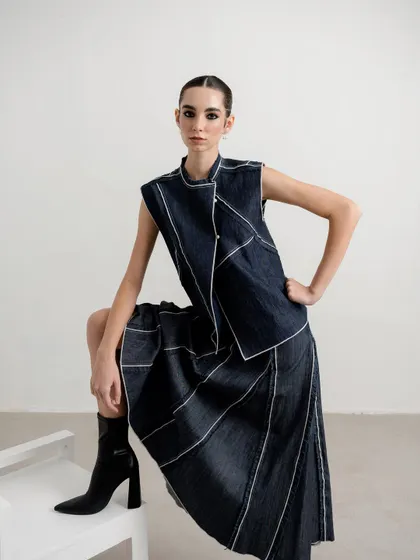 A minimalist studio shot for a contemporary womenswear brand. The styling is clean and sharp, focusing on the unique construction and contrast stitching of the denim two-piece. This demonstrates my ability to create compelling lookbook images that are both artistic and commercial.