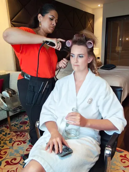 A behind the scenes shot of me styling her hair. Creating these soft, bouncy curls is a key step for a glamorous half-updo.