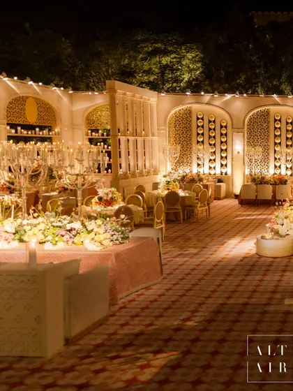 A wider view of the 'Sitara Mahal' dinner space, showcasing the custom-built arches with jaali work and shelves filled with candles. We transformed a bare lawn into a regal, contemporary palatial space.