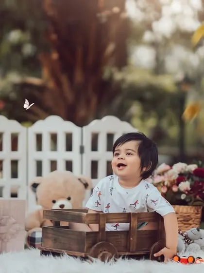 A classic first birthday portrait surrounded by his favorite things. This outdoor setup with "ONE" blocks and teddy bears creates a perfect scene to celebrate a year of wonderful adventures.