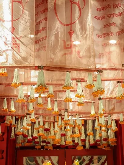 A closer look at the beautiful ceiling detail, with rows of marigold and tuberose tassels hanging from the script-printed fabric.