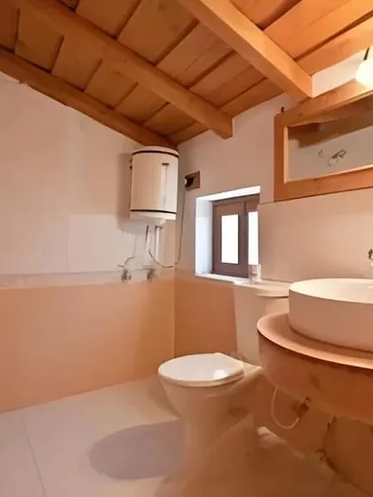 The bathroom design for the Eco Lodge, using simple, clean fixtures and a wooden vanity to continue the natural, rustic theme.
