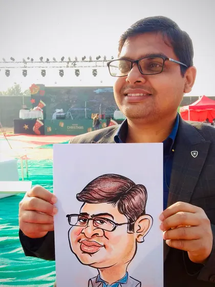 A guest poses with his finished caricature at an outdoor event. I make sure to get a good likeness while still keeping the portrait fun and exaggerated.