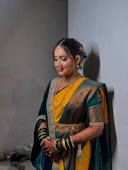 The bride's soft smile and glowing makeup. The traditional Maharashtrian nath (nose ring) is a key element of her look.