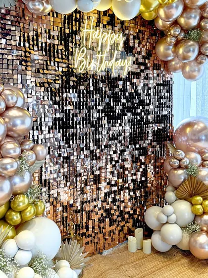 The "Happy Birthday" neon sign glowing against the rose gold sequin wall. This is the centerpiece of the decor, creating a perfect photo op.