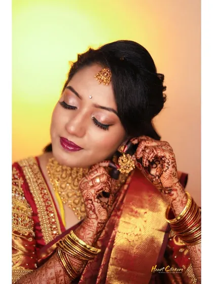 A close-up shot of the bride getting ready, putting on her traditional gold earrings.