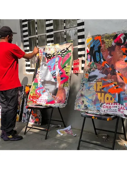 Here I am in the studio, working on a couple of pieces from the 'Stick No Bills' décollage series. This shot shows the scale of the canvases and the hands-on process of layering and painting.
