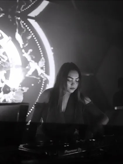 A moody black and white shot of me focused on the mix, with artistic visuals in the background.