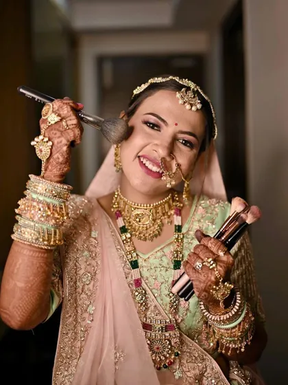 A fun and happy shot of a bride in her pastel green lehenga. This look is all about fresh, glowing skin and a bright smile.