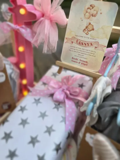 The personalized welcome card for Vannya, placed on a miniature easel, is a centerpiece of this elaborate baby girl trousseau.