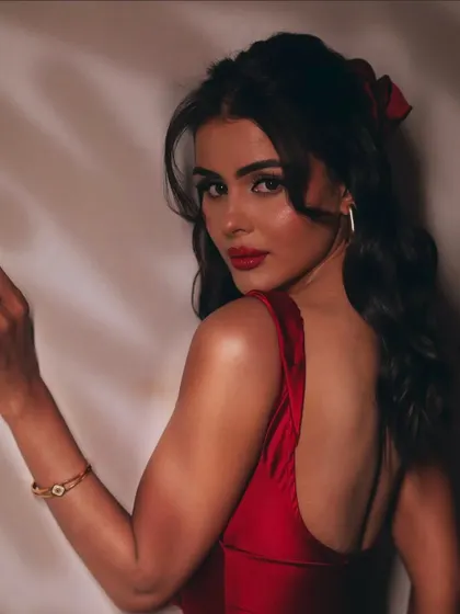 A final look back. This portrait showcases the entire look, from the soft updo with a red accessory to the flawless makeup.