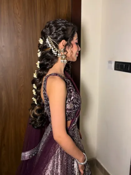 A side view of the braided hairstyle, showing the intricate passas and hair jewelry.