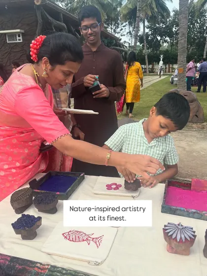 Nature-inspired artistry at its finest. A young boy gets a helping hand as he carefully presses a block onto a pouch. It's a wonderful activity that brings families together in a creative and fun way.