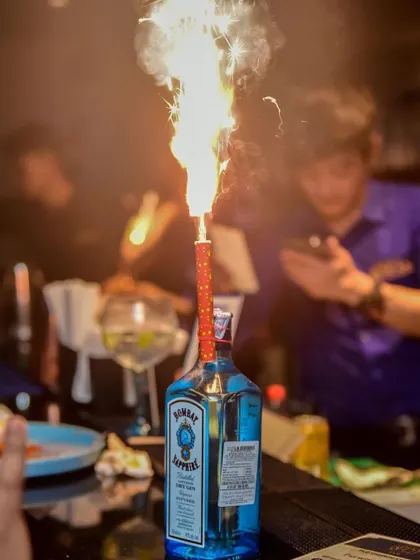 A bottle of Bombay Sapphire with a celebratory sparkler at the bar. This image captures the premium, high-energy party atmosphere that I strive to create at all my events.