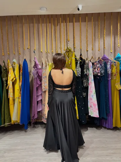 The back of this black outfit is the real showstopper. A deep backless design adds a touch of drama and glamour.