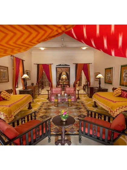 This vibrant hotel room is captured with a focus on symmetry and color. The bright textiles and traditional furniture are central to this interior design photograph.