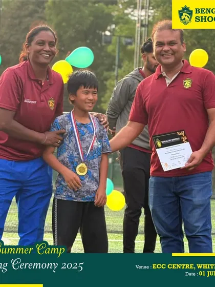 A proud moment as a summer camp participant receives his completion certificate and medal from our coaches.