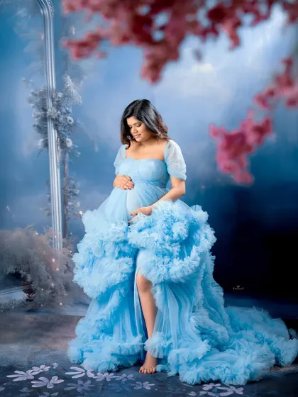 A dreamy and contemplative portrait. The mom-to-be is surrounded by a soft, misty blue atmosphere, creating a peaceful and magical scene.