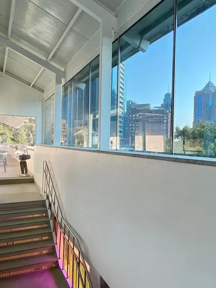 A view from the upper level of the Museum of Art and Photography (MAP) looking out towards the Bengaluru skyline. The circulation spaces are designed to be open and transparent, constantly connecting visitors back to the city context outside.