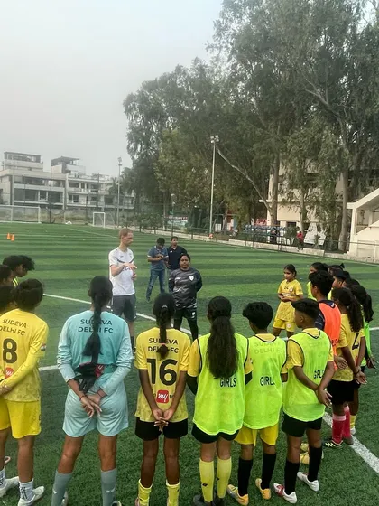 The girls' team gathers for a briefing from the VfB Stuttgart coach. Tactical understanding is as important as physical skill in our training philosophy, and our girls are eager learners.