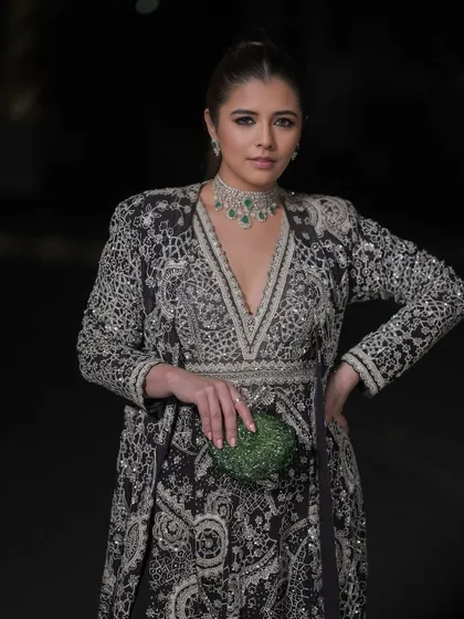 Major sangeet inspiration with this luminous and striking look. The makeup features a dewy finish and defined eyes that complement her intricate black and silver jacket lehenga.