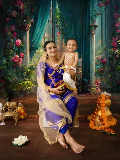 A mother and child in a beautiful, magical setting for their Janmashtami photoshoot. The colors and lighting create a dreamy effect.
