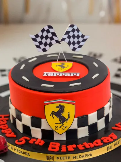 A detailed shot of the Ferrari cake, showing the classic logo and racetrack design.