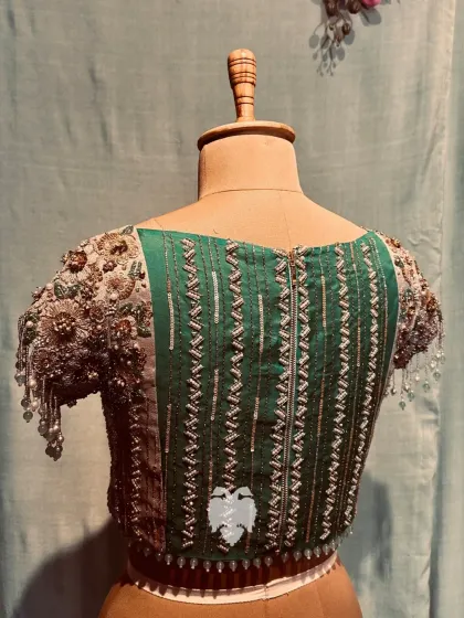 The back of Nithya's blouse, showing the linear embroidery on the deep green panel.