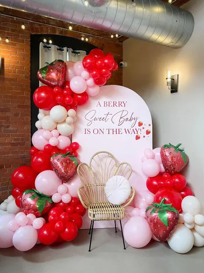 A "Berry Sweet Baby" is on the way with this adorable strawberry-themed baby shower. The red and pink balloon arch and strawberry foil balloons create a fun and fruity celebration.
