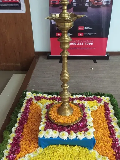A traditional lamp (diya) placed on a floral rangoli for a corporate event inauguration. This blend of tradition and business is perfect for opening ceremonies.