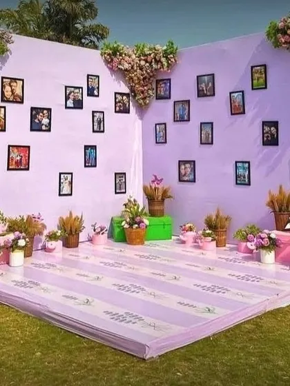 A personalized selfie corner with a lavender wall adorned with the couple's photos. Whimsical purple deer props add a unique and fun touch to the decor.