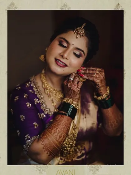 A bride getting ready, wearing her custom purple embroidered blouse. The image captures the rich color and intricate detail of the handwork.