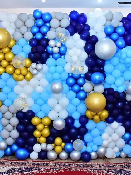 A coustamised balloon wall decoration in shades of blue, silver, and gold. This makes for an incredible photo backdrop and adds a major wow factor to any event.
