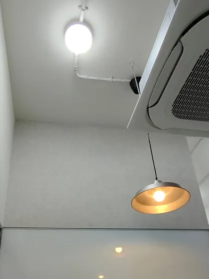 Another view of a textured wallpaper installation, showing clean work around lighting and an AC unit.